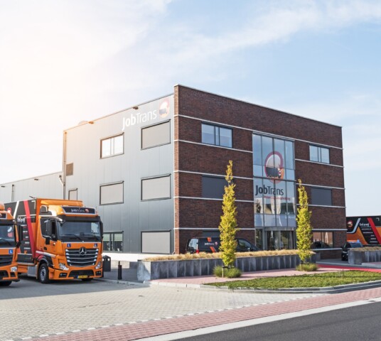 Vrachtwagens naast pand